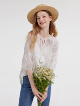 a lady in white embroidery blouse holding flowers